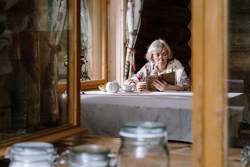 senior woman reading in her dining room