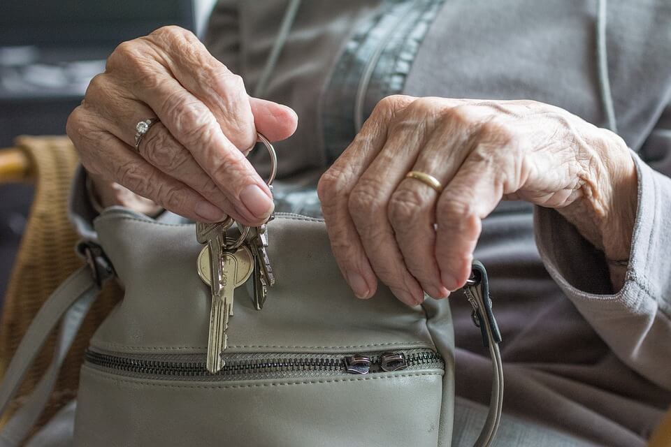 person putting keys in bag