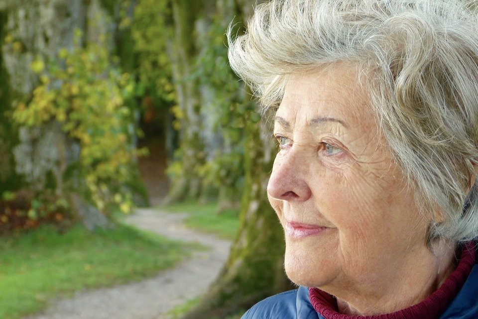 retired woman gazing at trees